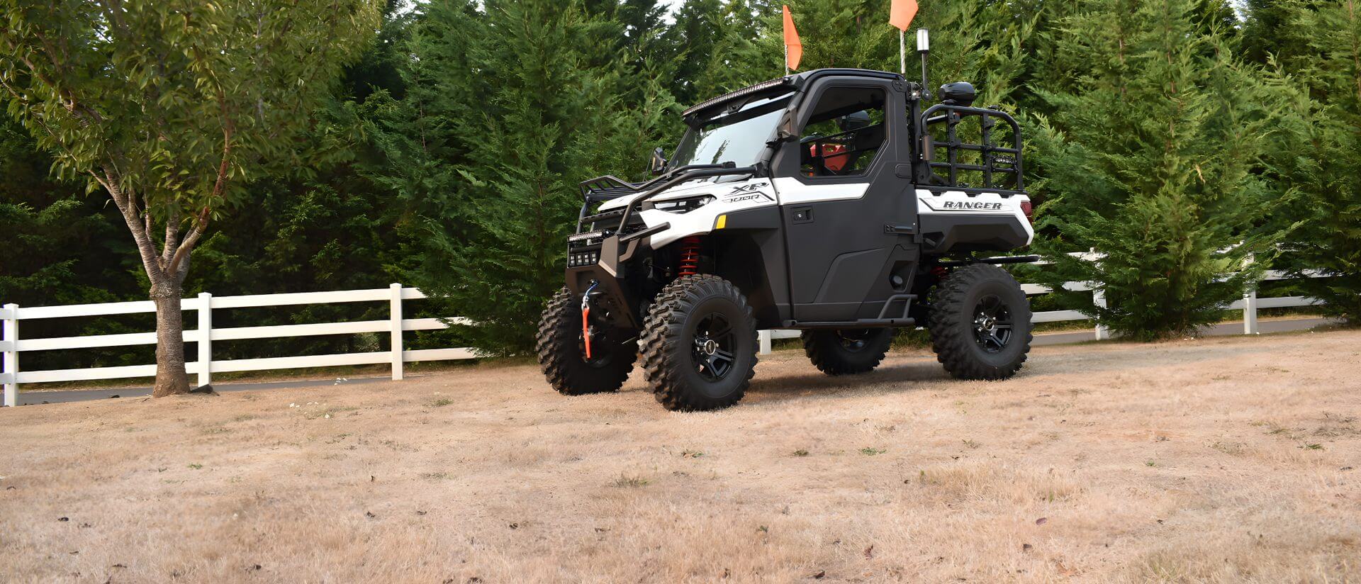 A black and white utility vehicle parked in the dirt.