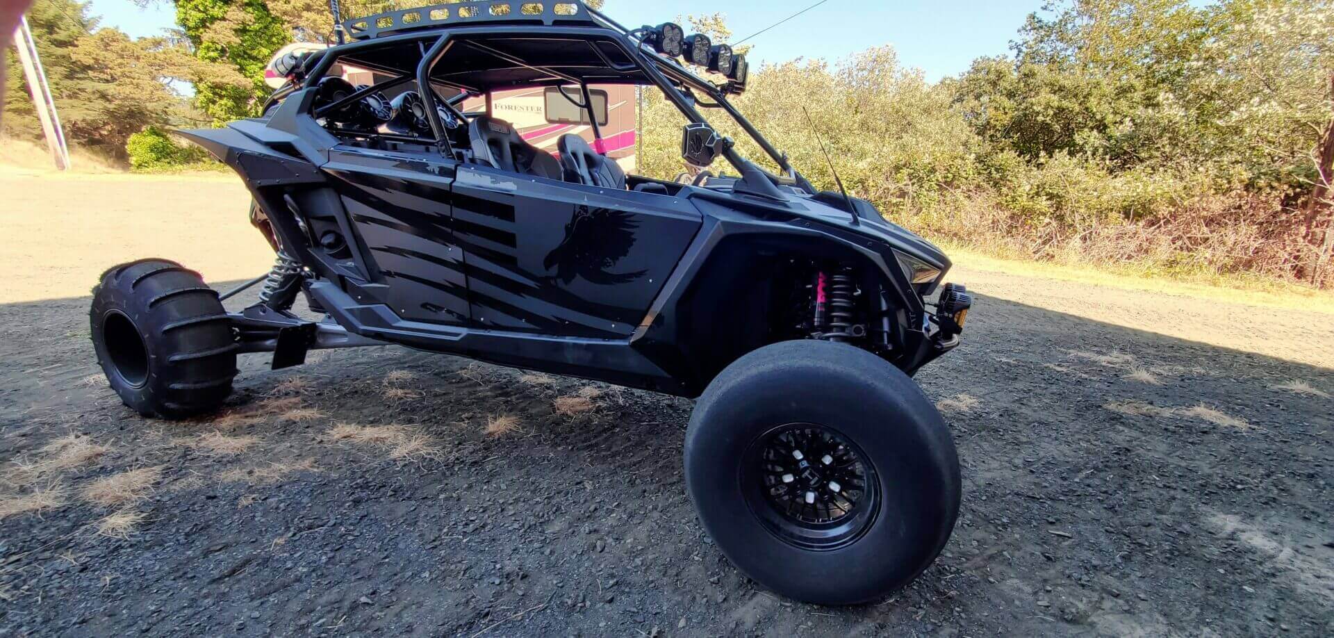 Black off-road vehicle parked on gravel.