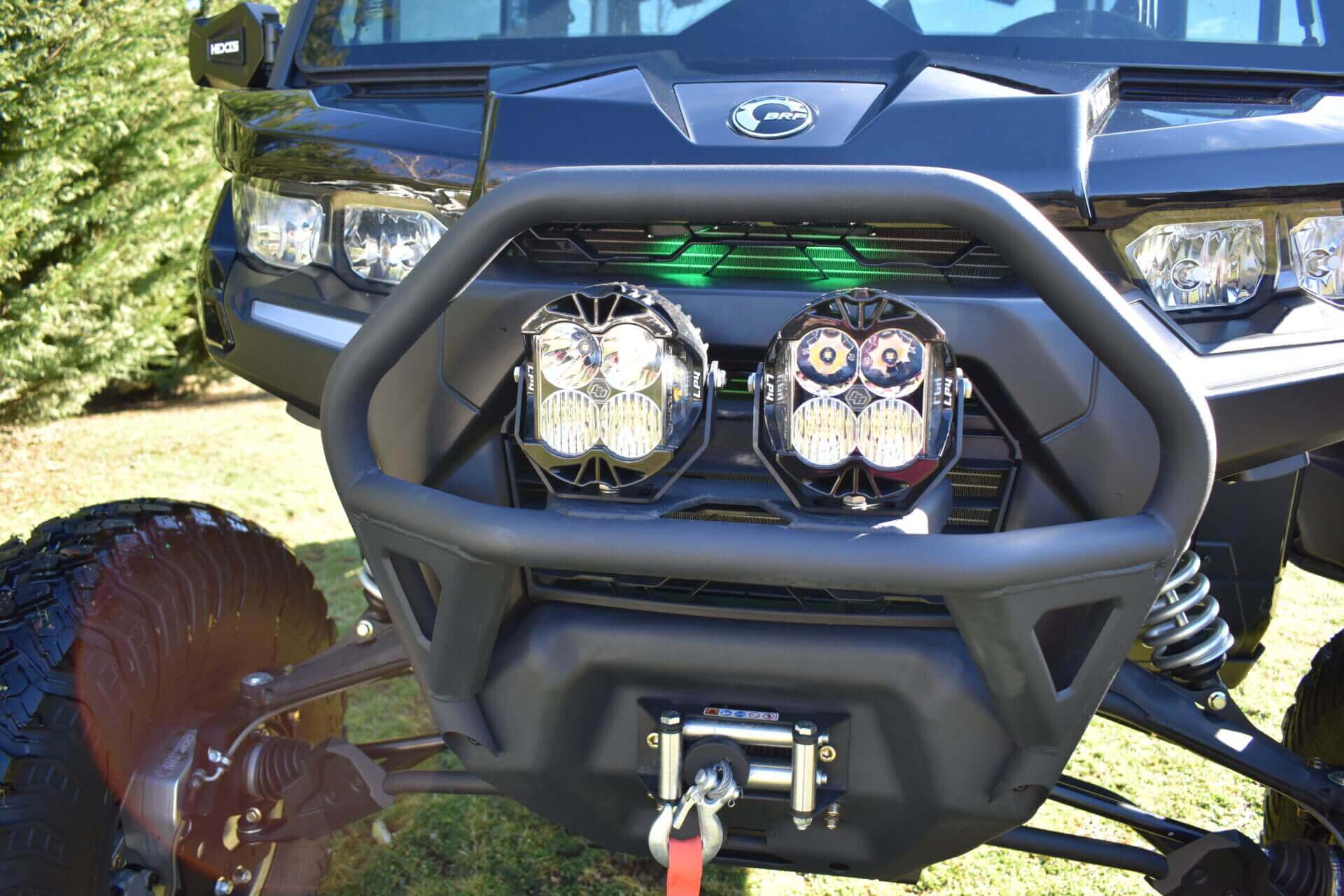 headlight of a vehicle up close with trees in the back.