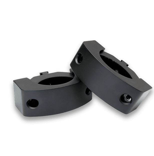 Two black mechanical components on black background.