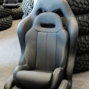 Black racing seat with stacked tires background.