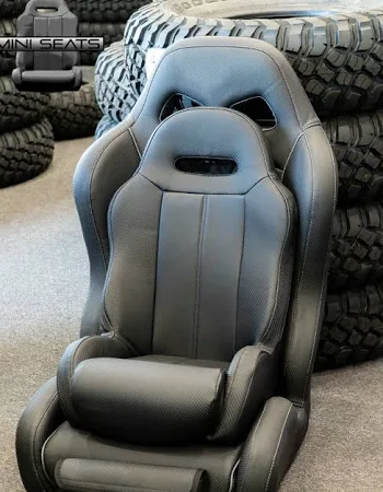 Black racing seat with stacked tires background.